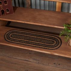 a black and gold rug on the floor next to stairs with a potted plant