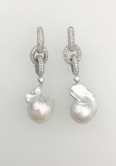 Stunning cultured freshwater Baroque pearls on an interlocking pavé rhodium plated chain.  Chain-link is available in 18K White-gold, 18K Rose-gold or 18K Yellow-gold plated over sterling silver.  PEARLS ARE 20-25mm; earrings are approx. 2 ¼" long.  Enhancer sold separately. Please note: Due to the unique and natural origin of pearls, slight variations may occur.  These characteristics enhance the beauty of the product and truly make them a one of a kind piece. Luxury Pearl Chain Sterling Silver Earrings, Luxury Briolette Pearl Earrings, Luxury Pearl Chain Drop Earrings, Silver Akoya Pearl Chain Earrings, Luxury Dangle Earrings With Pearl Chain, Luxury White Pearl Chain Earrings, Luxury Silver Earrings With Pearl Chain, Luxury Silver Pearl Chain Earrings, Luxury White Gold Earrings With Pearl Charm