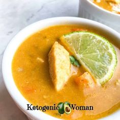 two bowls filled with soup and garnished with lime