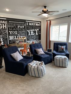 a living room filled with furniture and chalkboard walls