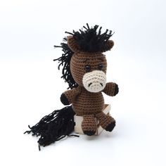 a crocheted stuffed horse sitting on top of a white surface