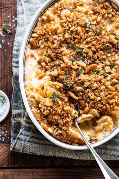 a casserole dish filled with meat and cheese on a napkin next to a spoon