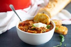 a bowl of chili with bread on the side