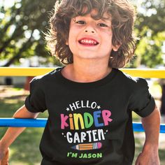 Designed to make the first day of school extra special, this "Hello Kindergarten" Kid's T-Shirt is perfect for celebrating your child's milestone in style and sets the stage for a fantastic academic journey. Personalize it with your kid's name to make him feel like a superstar as he embarks on his kindergarten adventure. Black Graphic Print T-shirt For Back To School, Kindergarten T Shirts, Kindergarten Shirts For Boys, Kindergarten T Shirts For Kids, Back To School Short Sleeve Shirt With Name Print, Kindergarten Shirts For Kids First Day, School T Shirts, Hello Kindergarten, Shirts For Boys