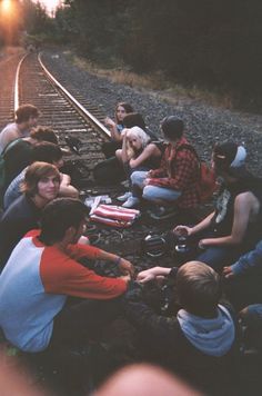 a group of people sitting next to each other on train tracks with the words graded above them