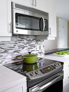 a stove top oven sitting inside of a kitchen next to a microwave and dishwasher