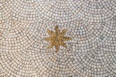 a mosaic tile floor with a golden star on it