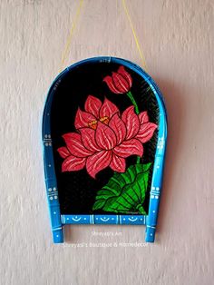 a painted flower on a wall hanging from the side of a white wall with blue trim