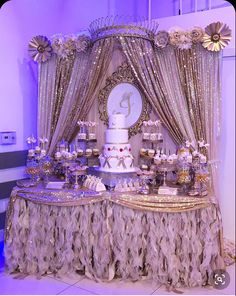 a table topped with a white cake covered in frosting and lots of gold decorations