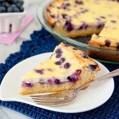 a slice of blueberry cheesecake on a plate with a fork next to it