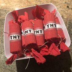 four rolls of red tissue wrapped in twine with the word tnt on them