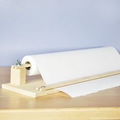 a roll of toilet paper sitting on top of a wooden table