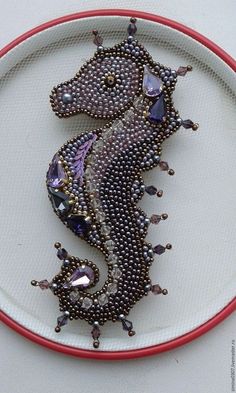 a beaded sea horse on a white plate