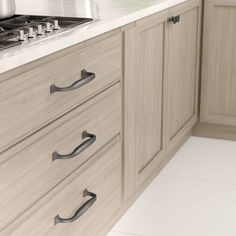 an image of a kitchen setting with white countertops and beige cupboards that have handles on them