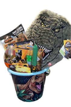 a dinosaur bucket filled with toys and other items to be used as a birthday gift