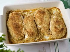 a casserole dish filled with chicken breast covered in gravy and parmesan cheese