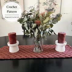 a vase filled with flowers sitting on top of a wooden table next to two candles