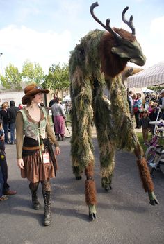 a woman is dressed up as a deer and standing next to a man in costume