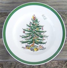 a plate with a christmas tree painted on the side and green trim around the edge