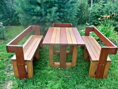 a wooden table and bench sitting in the grass