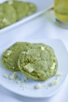 two green cookies on a white plate