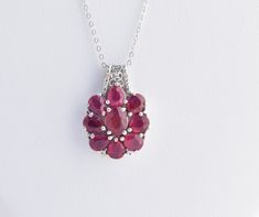 Genuine Ruby Necklace with Diamond Accents. - Rubies are sourced from a mine in Mozambique   - One center 8mm x 6mm ruby oval center stone is surrounded by eight 6mm x 5mm pear shaped rubies - Two genuine diamond accent chips are set in the silver pendant bail - Pendant is set in Platinum Over 925 Sterling Silver, Nickel Free hangs from a 20" 925 Sterling Silver chain - July birthstone Jewelry From (My Mom's) Estate Collection -- Mint Condition -- Appears Never Worn -- Year Unknown (Est. Vintage 1990-2000)  FREE SHIPPING * This item will ship with a complimentary gift box or pouch, perfectly packaged via USPS First Class mail with tracking * This cost is included in the price! Ruby Flower, Pendant Bail, Ruby Birthstone, Pendant Bails, July Birthstone Jewelry, Ruby Pendant, Ruby Necklace, July Birthstone, 925 Sterling Silver Chain