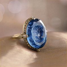 "As soon as this charming ring comes into your possession, you'll notice the details that contribute to its beauty. The intaglio is a reverse cameo with an incised, etched image and is handmade, using the very same process used by Bohemian glass makers of the last centuries. Beloved by Catherine the Great, intaglios were made in glass, agate, even lava -- all treasured for their exquisite detail. We set the intaglio into a delicate, yet sizeable ring design with an open bezel and under-gallery, Antique Oval Sapphire Diamond Ring, Vintage Sapphire Gemstone Diamond Ring, Heirloom Sapphire Ring Jewelry, Exquisite Collectible Ring Jewelry, Antique Oval Sapphire Ring, Vintage Oval Sapphire Jewelry, Fine Jewelry Diamond Intaglio, Victorian Sapphire Oval Rings, Fine Jewelry Diamond With Intaglio Detail