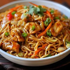 a white bowl filled with noodles and chicken