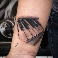 a black and white photo of a piano tattoo