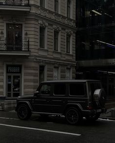 a black jeep parked in front of a tall building