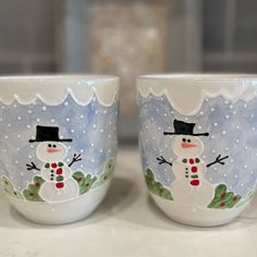 two frosty cups with snowmen painted on them