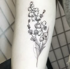 a small flower tattoo on the left arm is shown in black and grey ink, along with other flowers