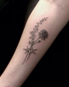 a black and white flower tattoo on the arm