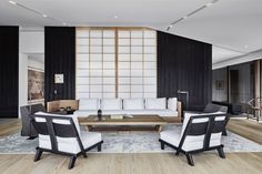 a living room with black and white furniture in it's centerpiece, along with wood flooring