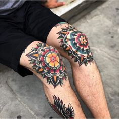 two men with tattoos on their legs sitting next to each other