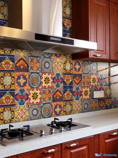 a stove top oven sitting next to a wall covered in colorful tiled backsplash