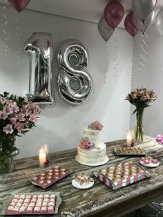 a table topped with lots of desserts and balloons