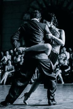 a man and woman dance in front of an audience