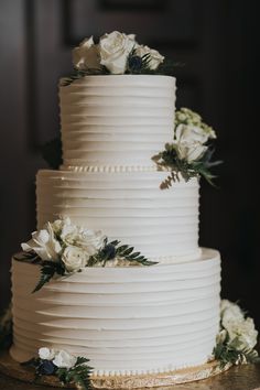 a wedding cake with white flowers and greenery