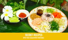 a plate full of food sitting on top of a green leafy table next to flowers