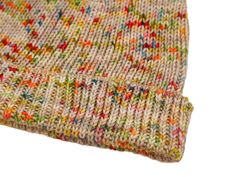 a close up view of a knitted blanket on a white background with multicolored dots