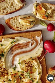 an assortment of breads and other food items on a cutting board with radishes