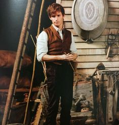 a man standing in front of a building with a clock on it's wall