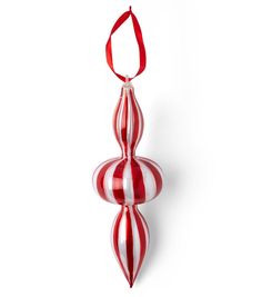 a red and white striped ornament hanging from a red ribbon on a white wall