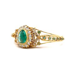 This beautiful vintage Mid-Century bracelet features a cabochon cut pear shaped emerald in the center with diamond accents. The cabochon-cut emerald, securely bezel set in the center is surrounded by a halo cluster of sparkling diamonds. The secondary accent stone is additional emeralds, adding an extra touch of elegance to this already breathtaking piece. This bracelet is a true masterpiece of the 1960s era, perfect for any occasion or as a timeless addition to your jewelry collection. Elegant Cabochon Jewelry For May Birthstone, Formal Cabochon Jewelry For May Birthstone, Elegant Cabochon Bracelets For Anniversary, Elegant Cabochon Emerald Ring For Formal Occasions, Elegant Formal Hand Set Emerald Ring, Elegant Hand Set Emerald Ring For Formal Occasions, Heirloom Pear-shaped Formal Jewelry, Formal Heirloom Pear-shaped Jewelry, Formal Hand Set Emerald Ring Fine Jewelry