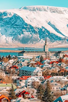 a city with mountains in the background and snow on the top of it's peaks