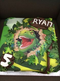 a dinosaur themed birthday cake in a box