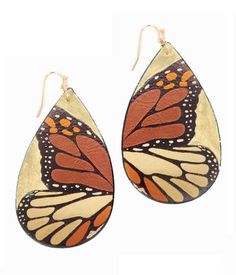 a pair of earrings with a butterfly design on the front and back of it's wings