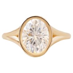 a yellow gold ring with a round diamond in the center