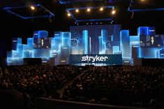 the stage is set up for an event with large screens on it and people sitting in chairs